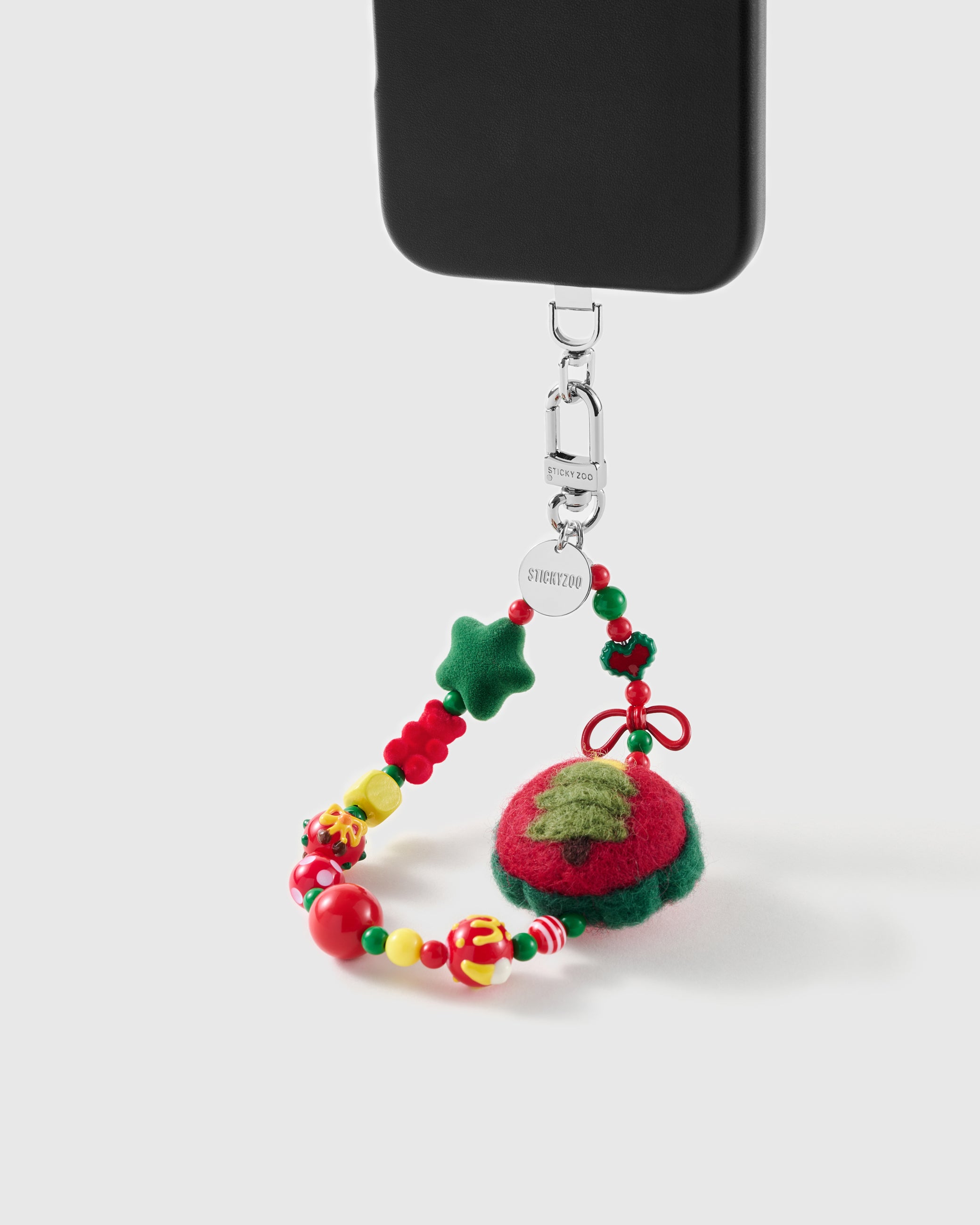 Christmas Tree wrist strap clipped to a black phone case for hands-free carry