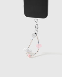 Blush Cloud wrist strap clipped to a black phone case for hands-free carry
