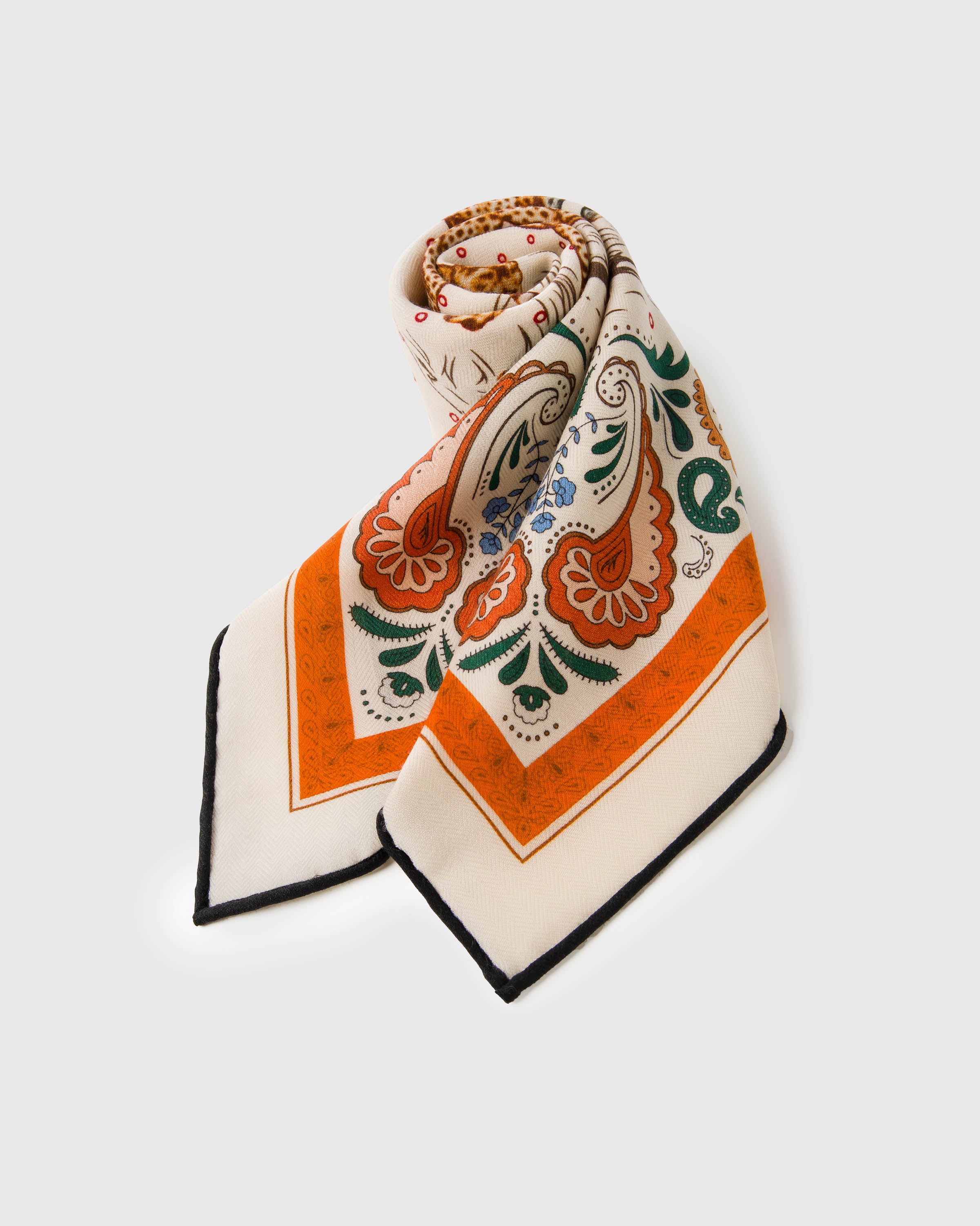STICKYZOO cheetah hunt silk scarf folded into a triangular drape with the paisley print catching the light
```