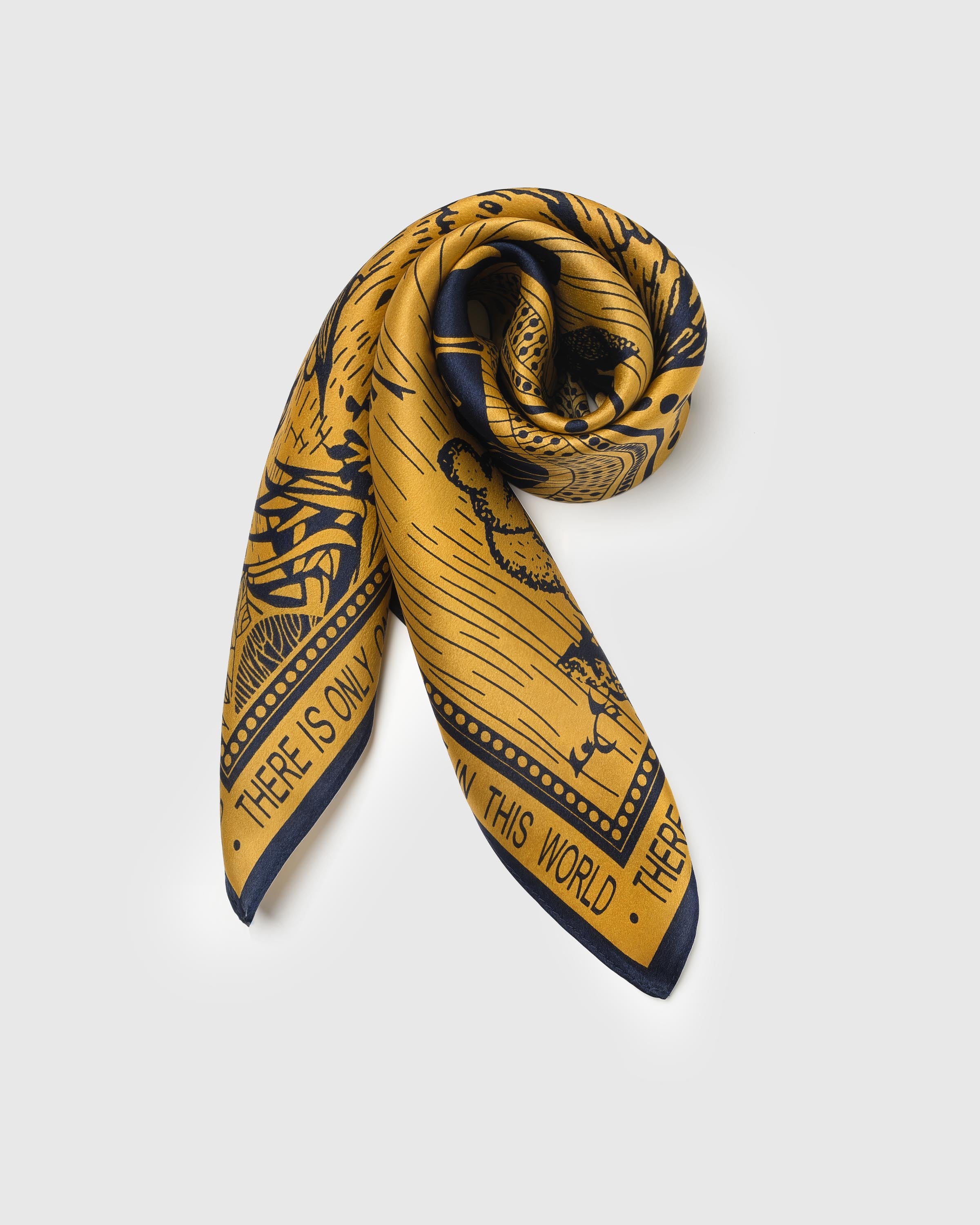 Folded silk scarf rolled along the diagonal showing the paradise scene meeting the block-text border
```