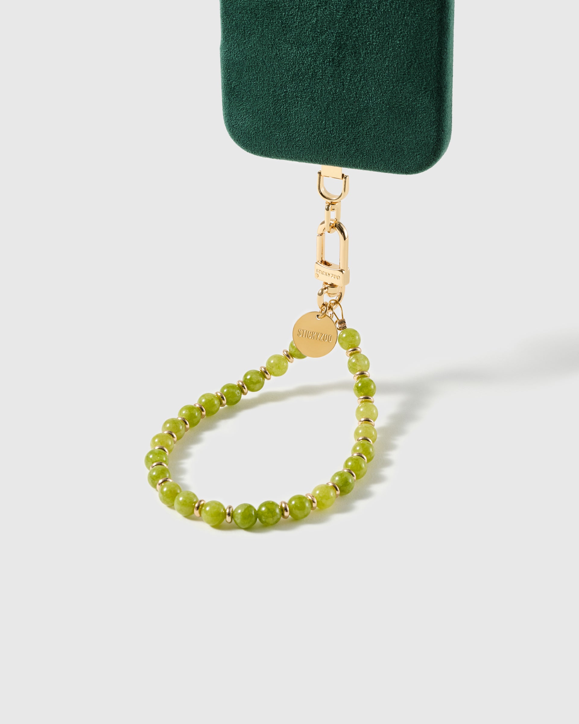 Olive-green stone bead phone strap attached to a phone case, gold clasp visible, showing universal fit