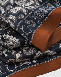 Cognac border meets the navy paisley field showing the silk drape and printed motif detail
```