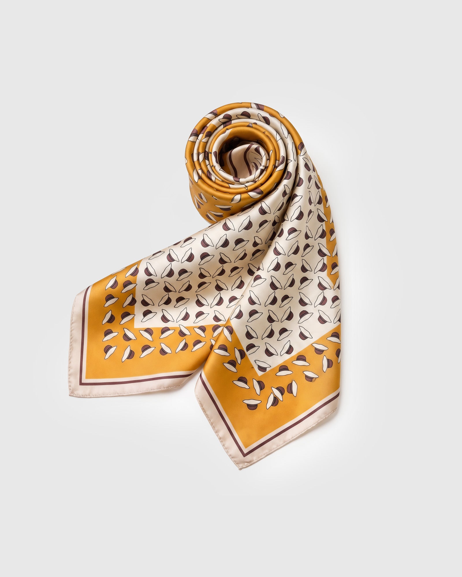 Saffron orchard silk scarf rolled and draped to show the small-square format and the petal print fanning across the fold
```