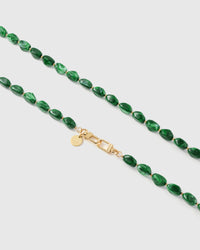 Close-up of deep green elongated marble-style beads with gold spacers and engraved STICKYZOO clasp