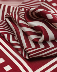 STICKYZOO crimson op-art silk scarf folded to show the optical depth of the concentric square print
```