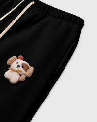Close-up of plush puppy with red beret on STICKYZOO black sweatpant showing waistband and drawstring