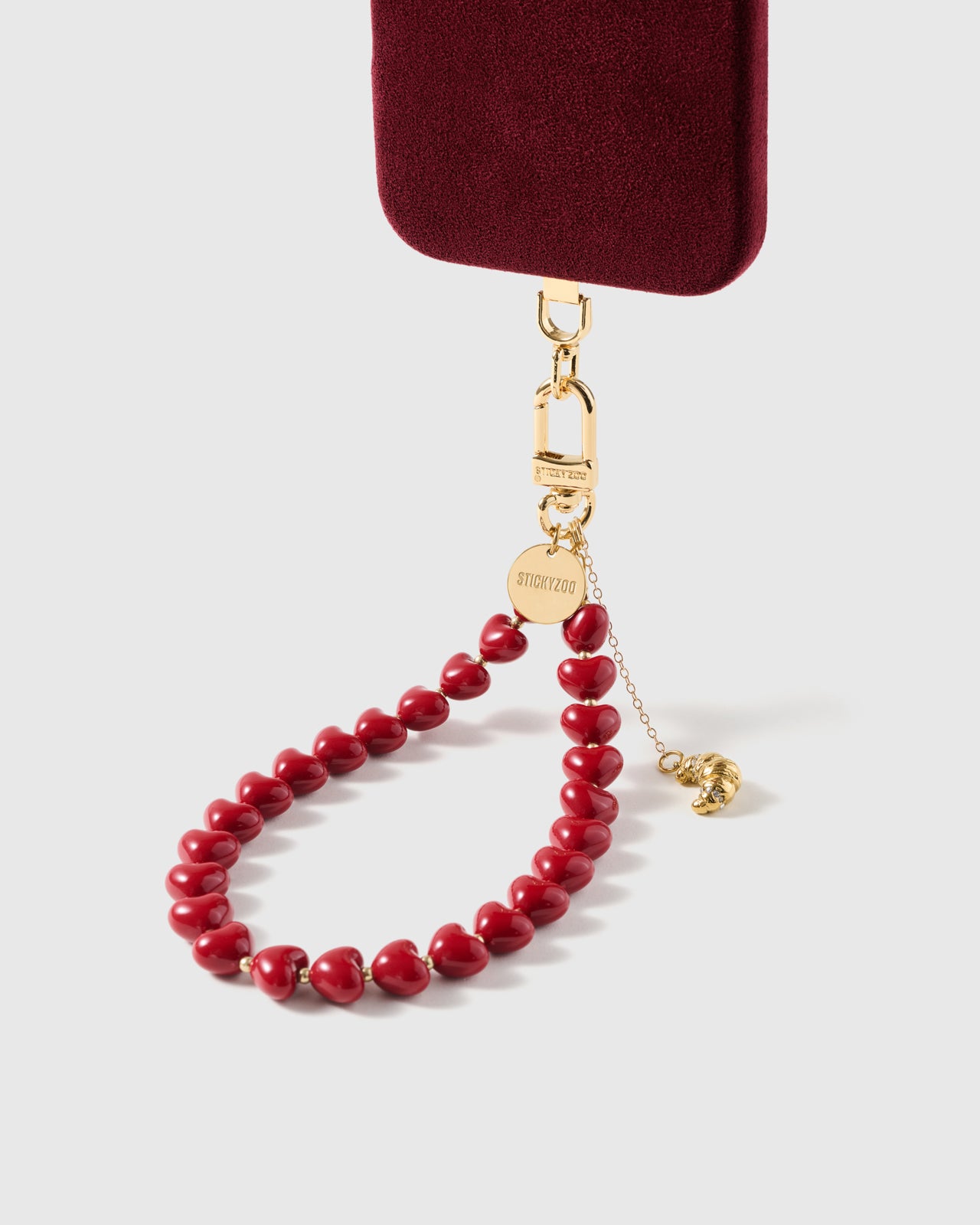 Gold croissant charm with crystal accents on fine drop chain swinging against glossy cherry resin heart beads — Loved by Thousands