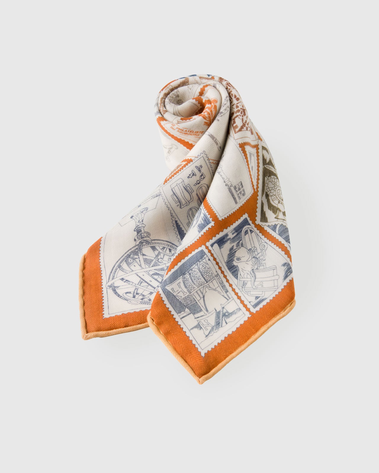 Silk scarf draped to show the stamp collage fanning across the silk and the terracotta border catching light
```