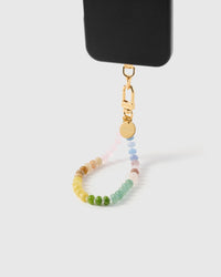 Rainbow agate orbit phone strap hanging from black phone case showing wrist carry functionality