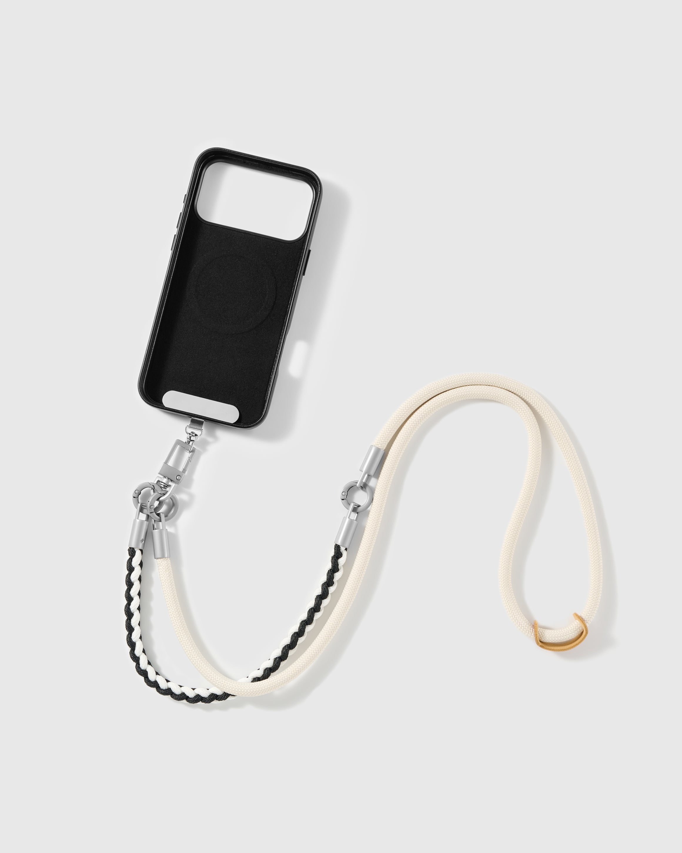 Phone worn cross-body on the ivory braided strap, hands-free for everyday carry