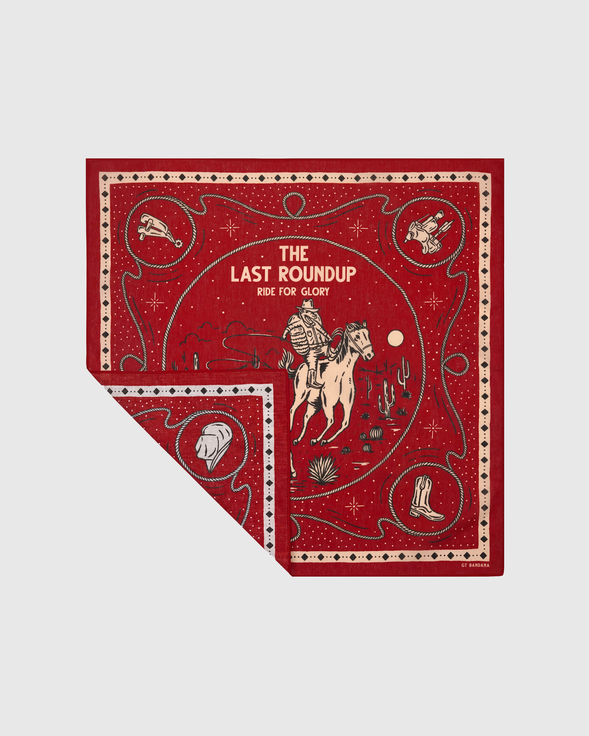 Cherry-red western silk scarf with a folded corner showing the cream-ink illustration and diamond border