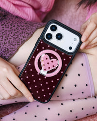 Burgundy starlight heart phone case held close with the heart-in-ring MagSafe kickstand extended