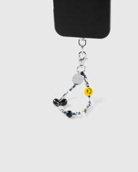 Smiley black heart phone strap attached to phone case showing hands-free wrist carry