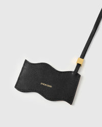 Back panel of UAE flag charm in black French Alran leather with gold debossed STICKYZOO branding
