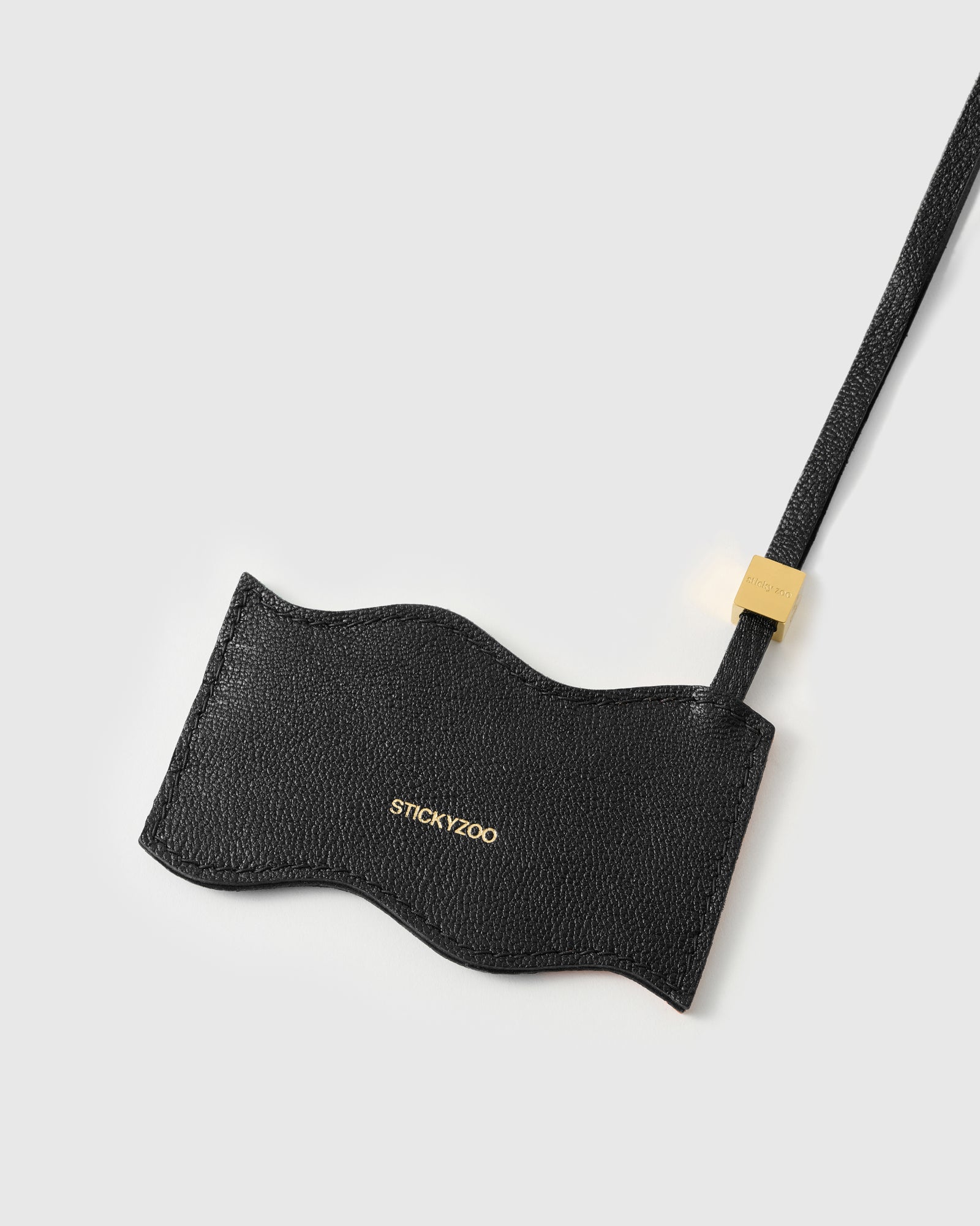 Back panel of UAE flag charm in black French Alran leather with gold debossed STICKYZOO branding