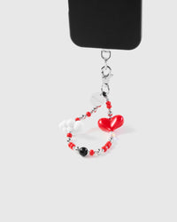 Crimson heart cloud phone strap hanging from black phone case showing wrist carry