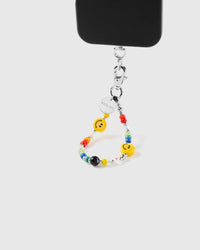 Saffron smiley phone strap hanging from black phone case showing wrist carry
