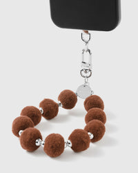 Close-up of brown plush pom-pom beads showing fuzzy texture and silver spacers