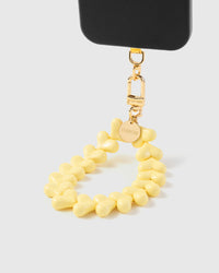 Close-up of interlocking pastel yellow heart beads showing glossy finish and sculptural shape
