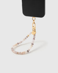 Blush agate orbit phone strap hanging from black phone case showing wrist carry functionality