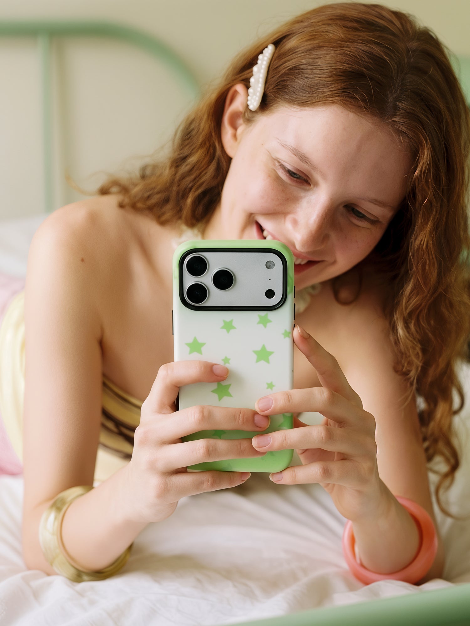 Hand holding the Lucky Star phone case while reading, fingers resting over the retractable MagSafe grip on the back.