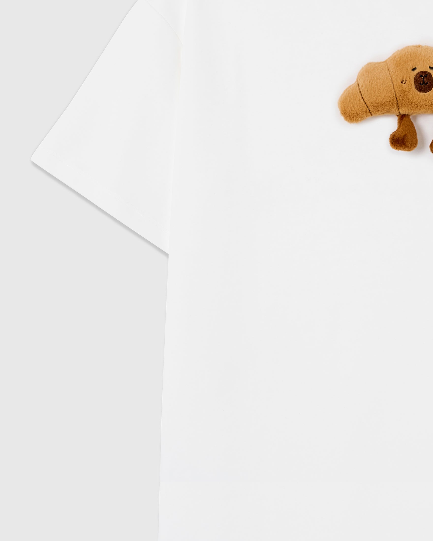 Detail of sleeve and side on STICKYZOO white Runaway Croissant T-Shirt showing boxy construction