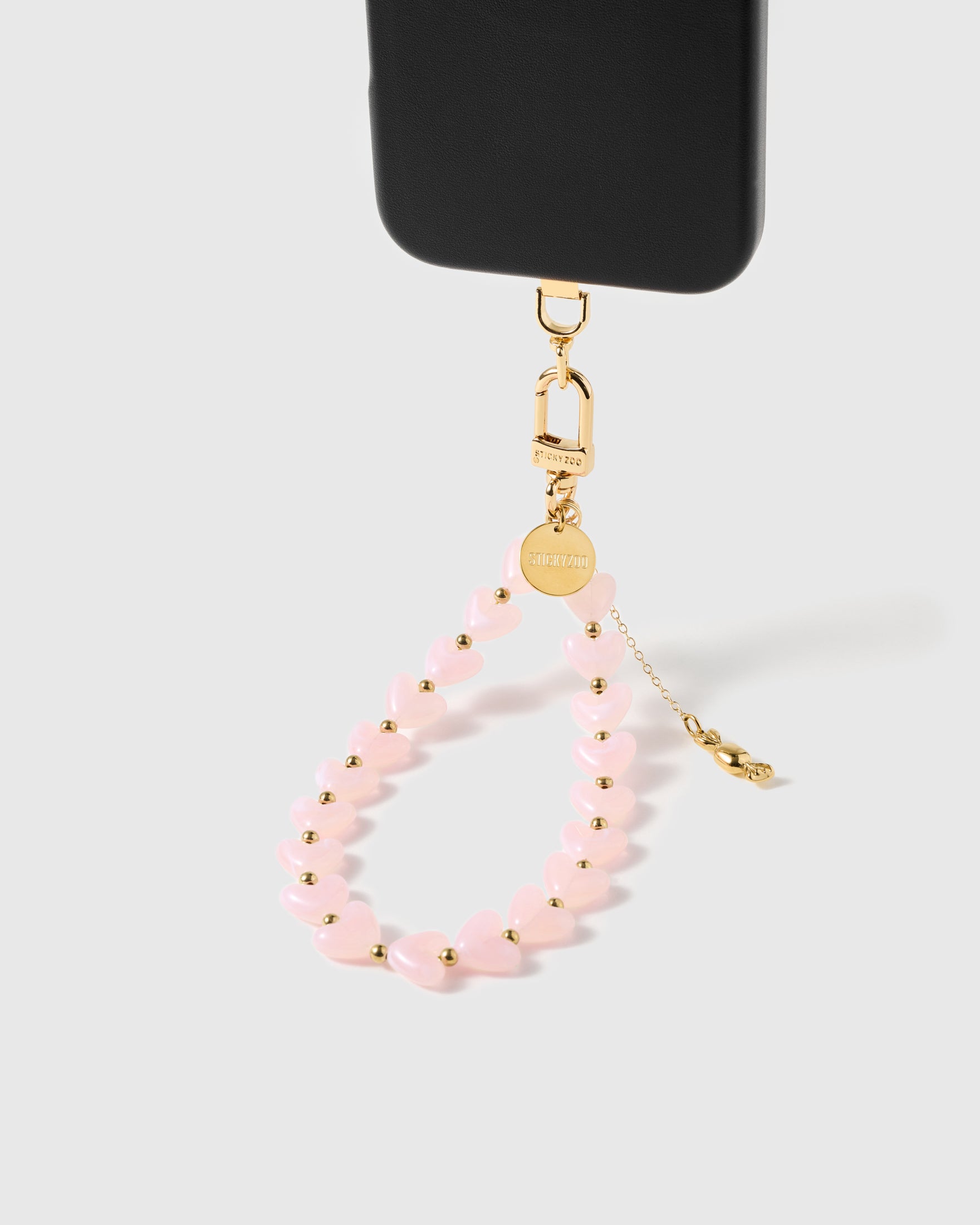 Close-up of pale pink pearlescent heart beads strung by hand with gold spacers between