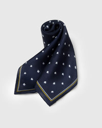 Silk regatta scarf coiled to show the deep navy drape and the soft hand of pure silk
```