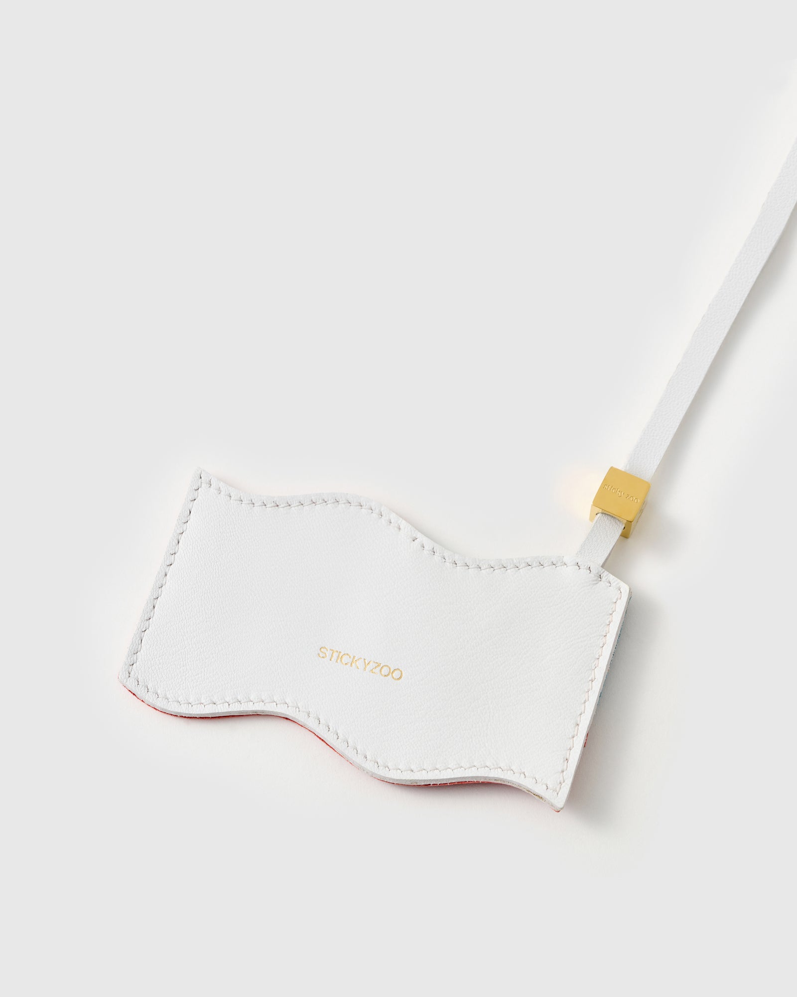 {{Every star, hand-cut}} Back panel of USA flag charm showing gold debossed STICKYZOO branding on leather