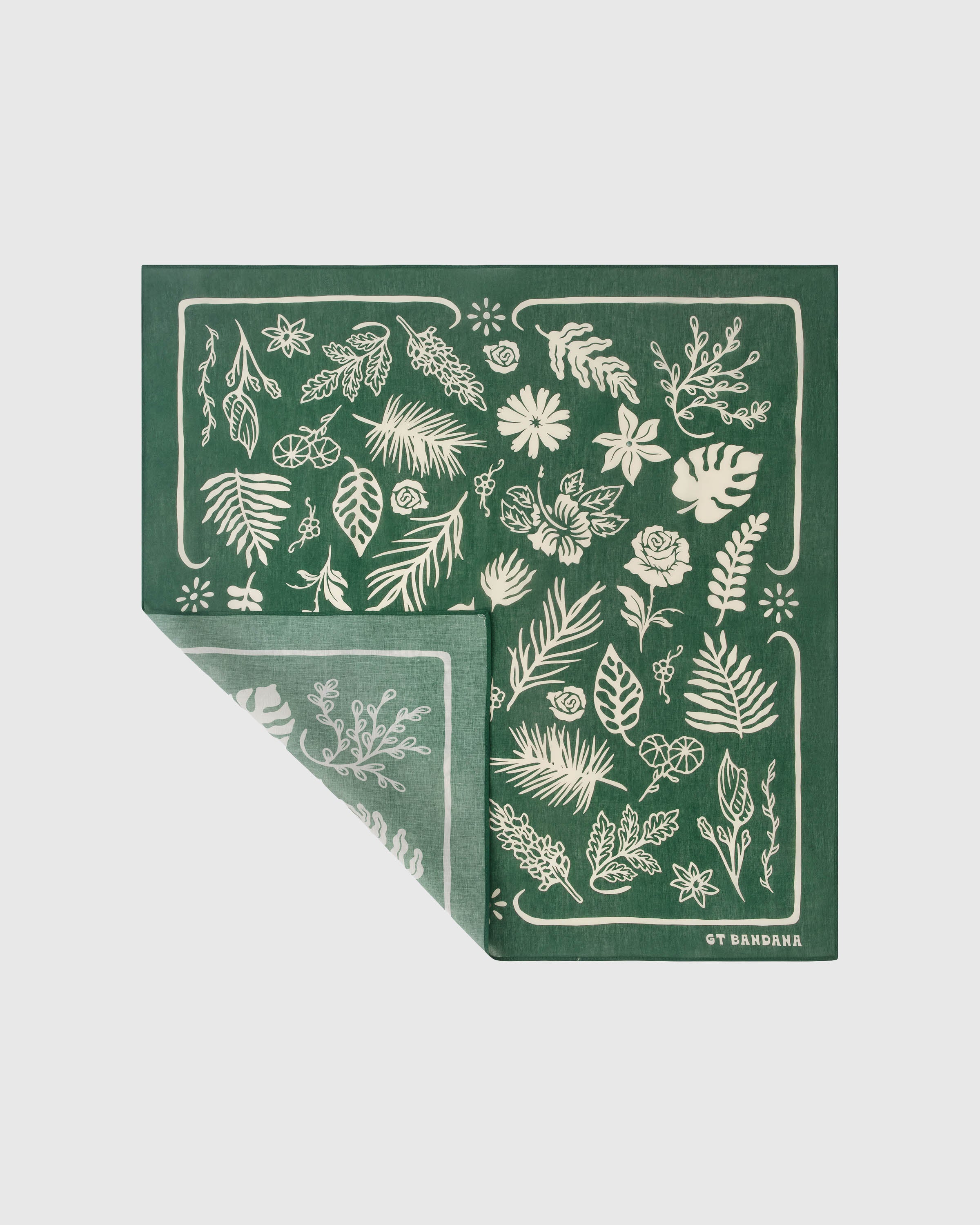 Silk herbarium scarf folded to show the forest-green field with scattered ivory botanical print