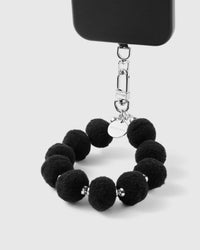 Close-up of black plush pom-pom beads showing soft fuzzy texture and silver spacers
