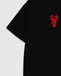 Detail of the raised lobster applique near the shoulder showing sequin tail scales and beaded antennae sewn onto black cotton.