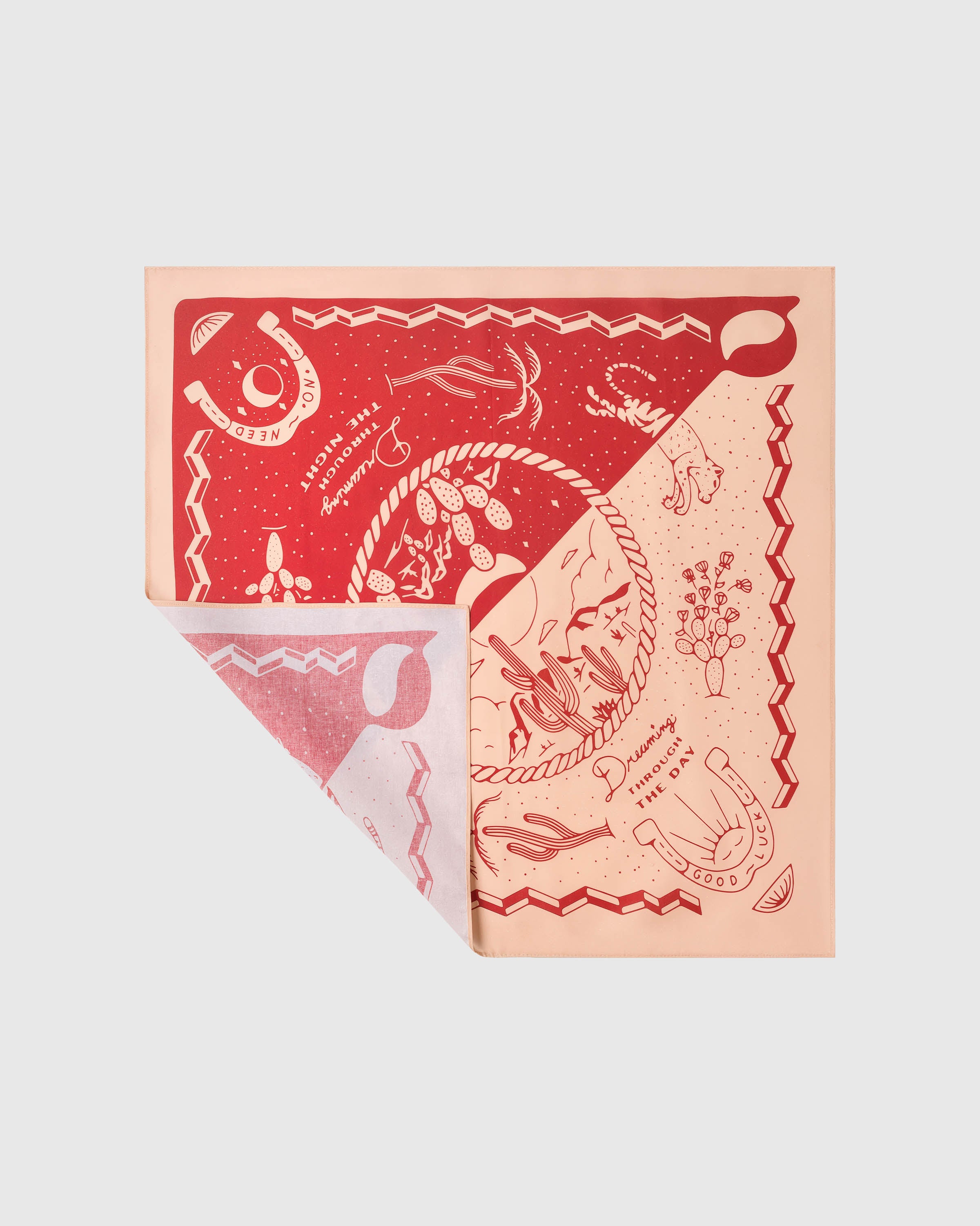 Silk scarf folded to show the red and peach diptych with cacti, lasso and horseshoe motifs