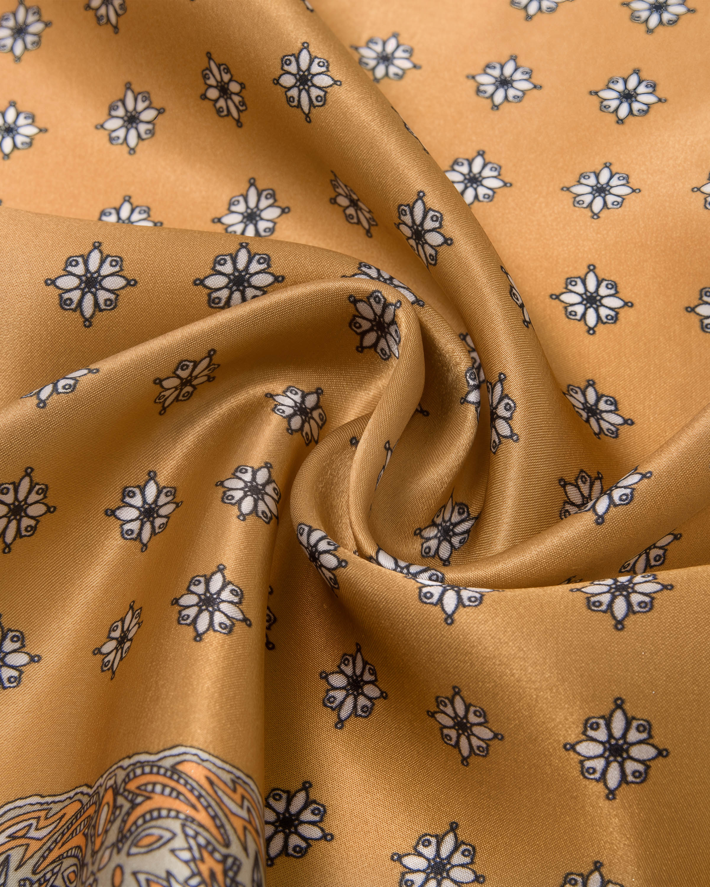 STICKYZOO amber silk scarf draped to show the white floral medallions printed on the warm silk field
```