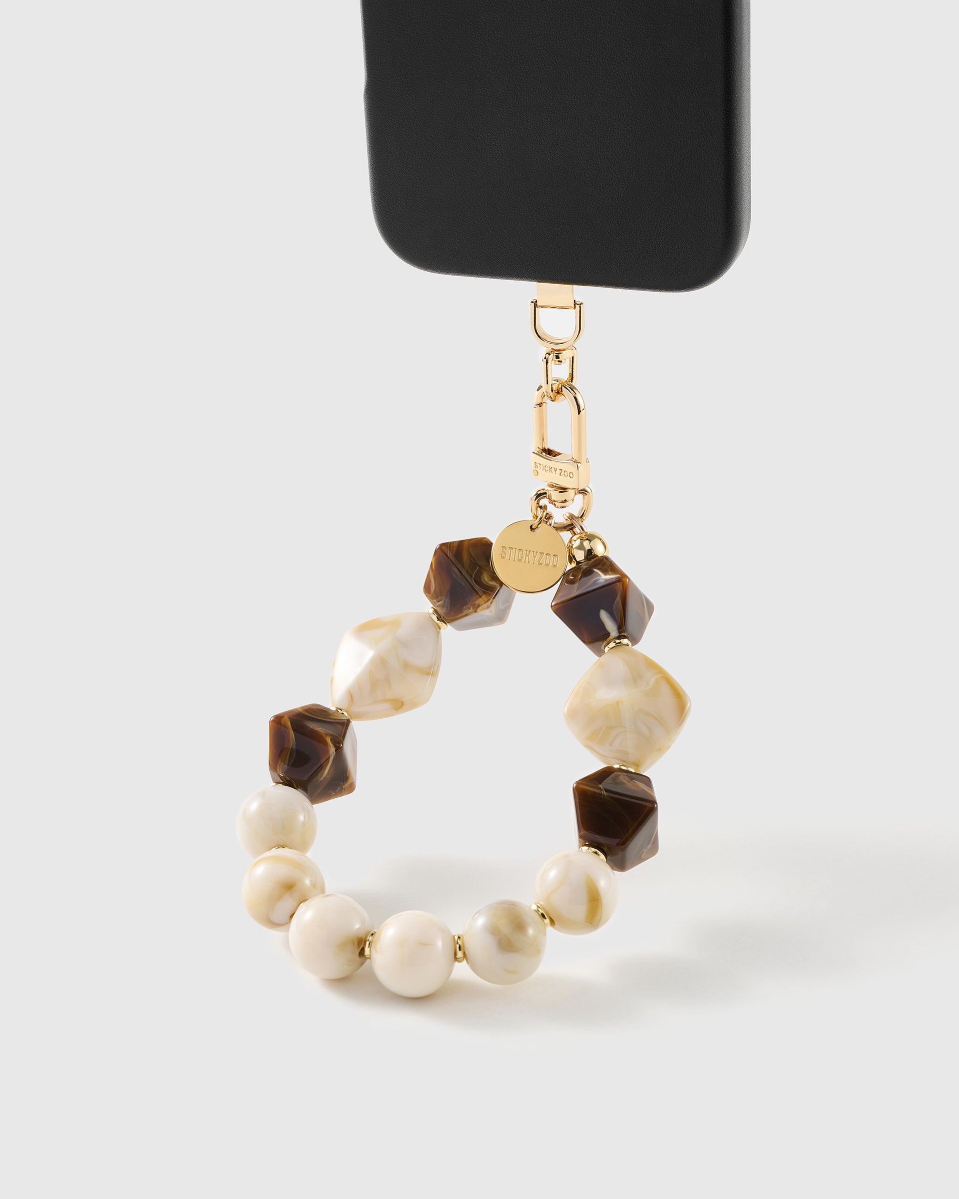 Mocha marbled bead wrist strap clipped to a black phone case for hands-free carry