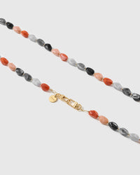 Macro close-up of polished resin nugget beads and the gold-plated clasp, each strap assembled by hand.