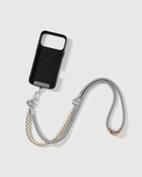 STICKYZOO cross-body phone strap laid flat beside a phone case it attaches to