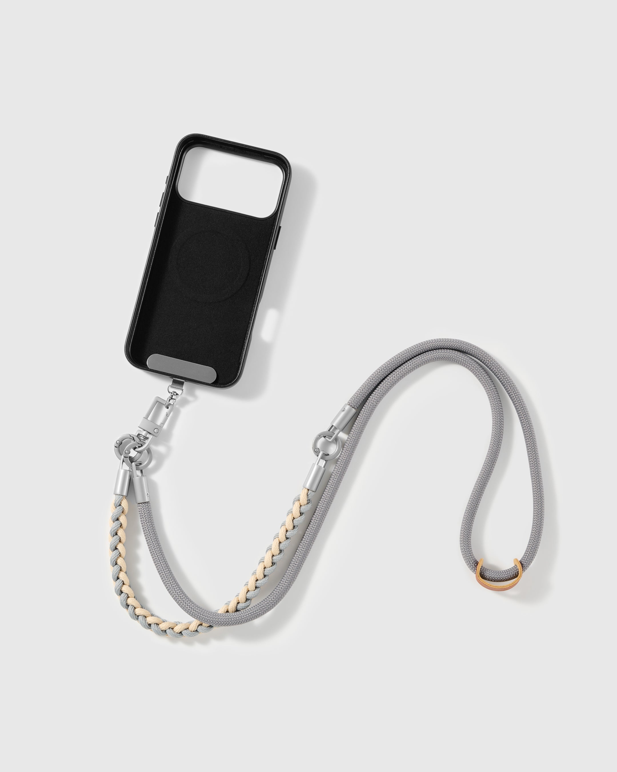 STICKYZOO cross-body phone strap laid flat beside a phone case it attaches to