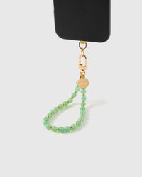 Sage orbit phone strap hanging from black phone case showing vibrant green stone beads