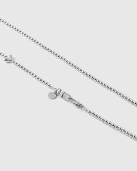 Close-up of the silver-tone ball-bead chain, dual clasp, round engraved disc and one puffy heart bead.