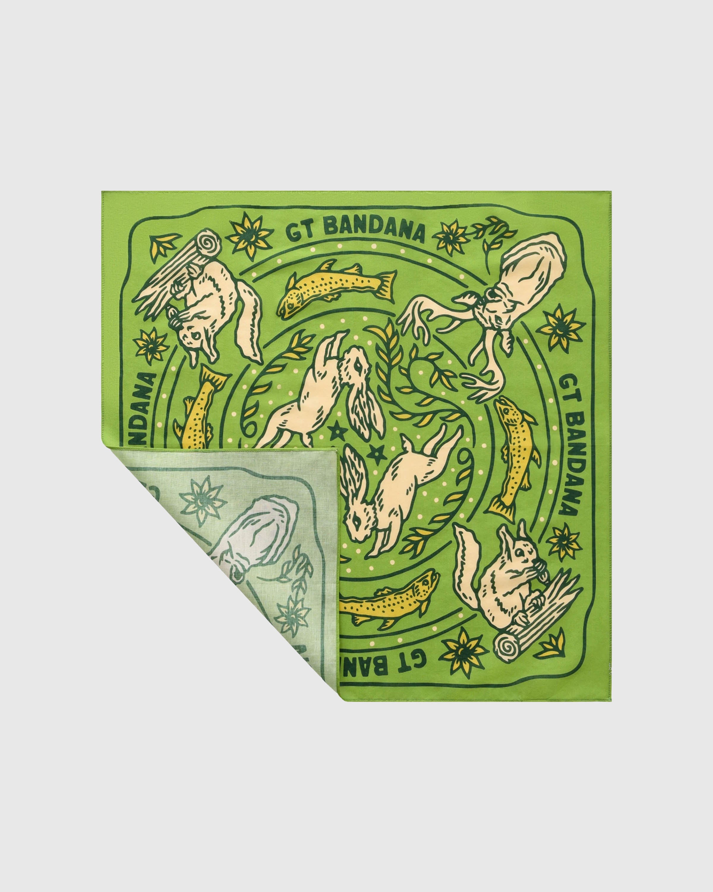 Meadow-green silk scarf with a folded corner showing the forest-green woodland print and brand cartouche
