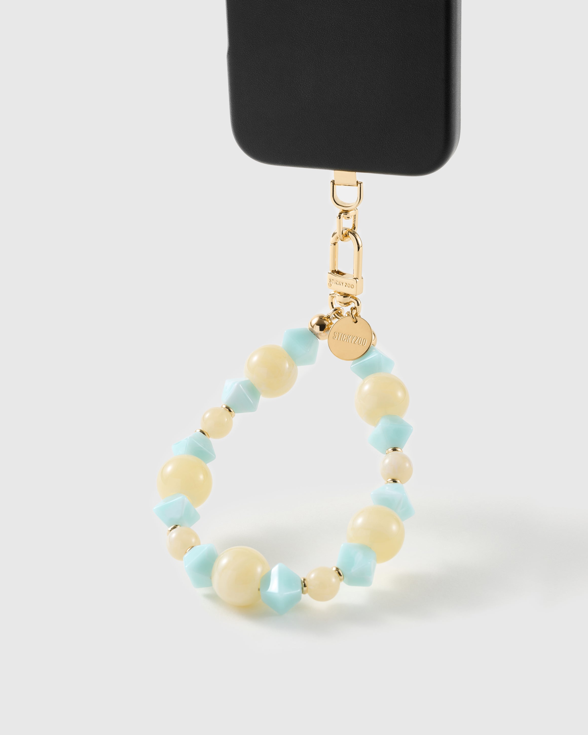 Aqua marbled bead wrist strap clipped to a black phone case for hands-free carry