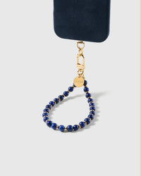 Cobalt-blue stone bead wrist strap clipped to a black phone case for hands-free carry