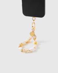 Amber marble stone strap hanging from black phone case showing warm golden veining in each bead