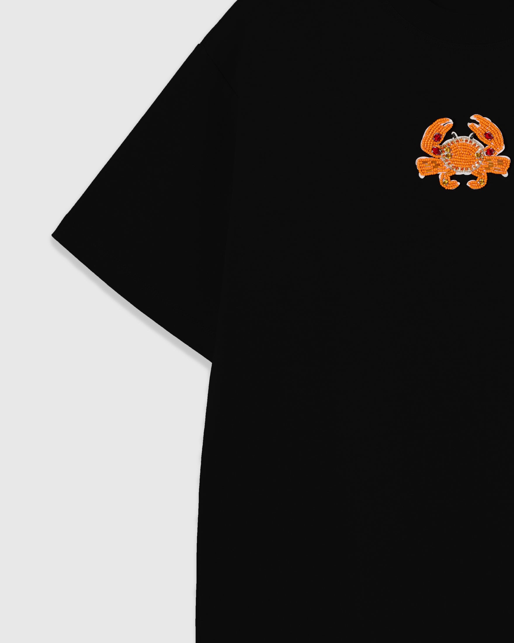 Detail of the Crab T-Shirt upper chest and dropped-shoulder seam with the beaded crab and 230gsm cool-touch cotton surface