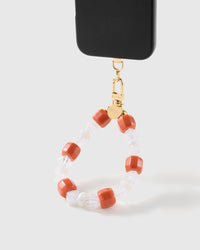 Clementine-orange bead wrist strap clipped to a black phone case for hands-free carry