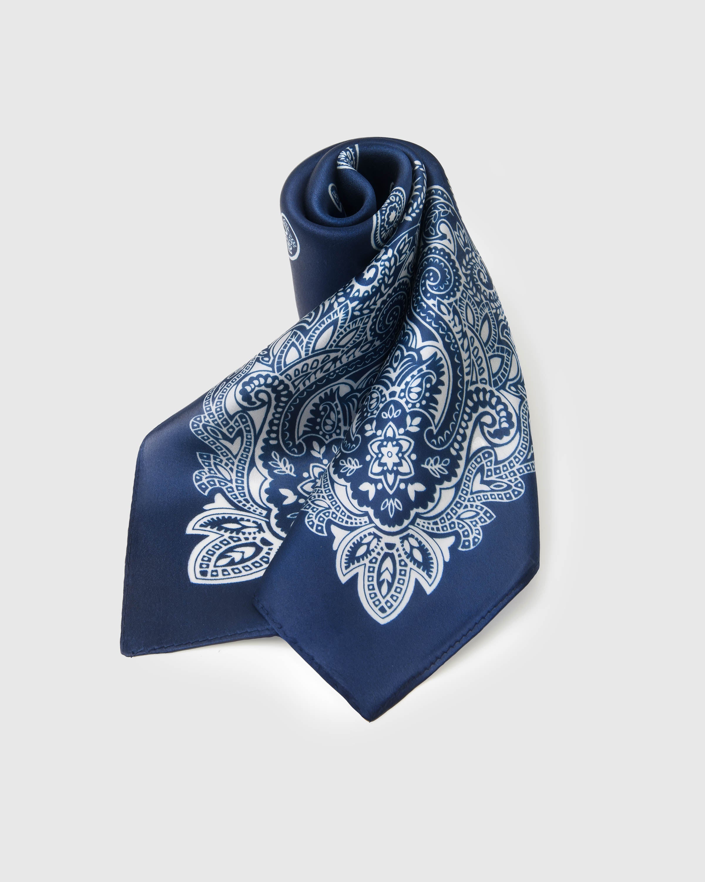 STICKYZOO indigo silk scarf coiled to show the soft drape and white medallion paisley print
```