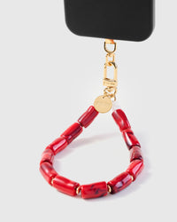 Ruby marble barrel bead phone strap hanging from black phone case showing wrist carry