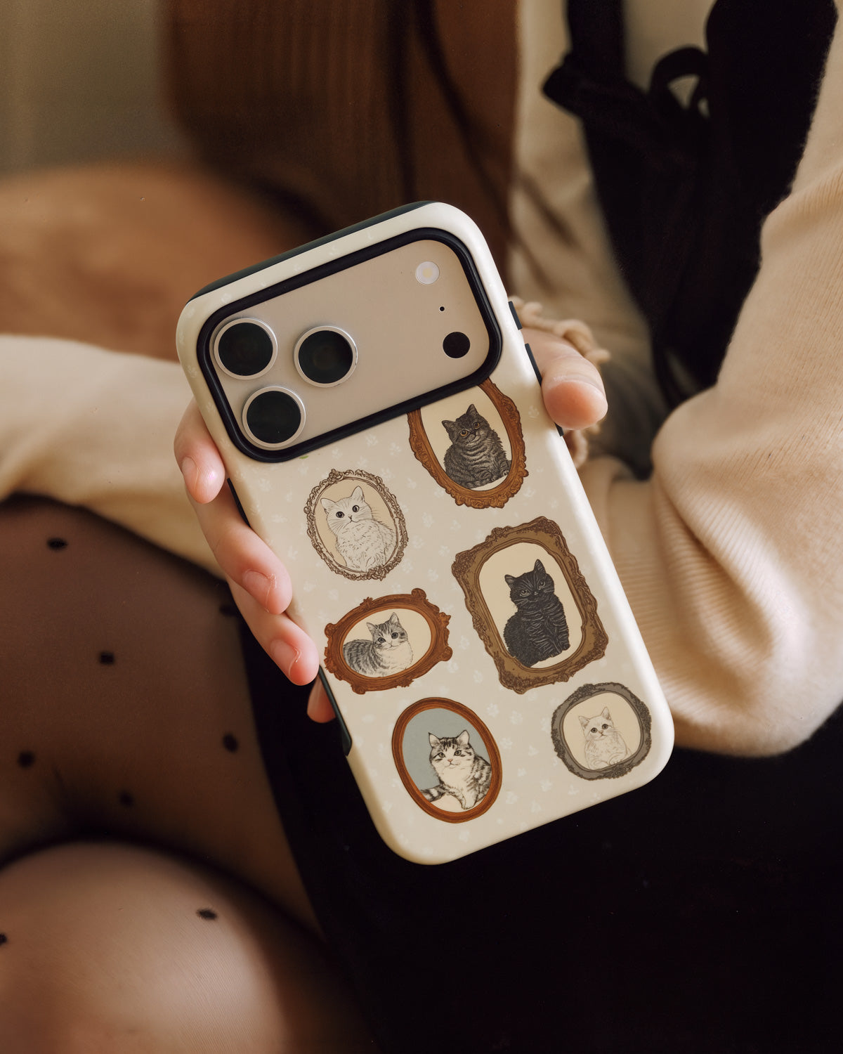 STICKYZOO vintage tabby phone case held in hand showing the cream gallery-wall print up close