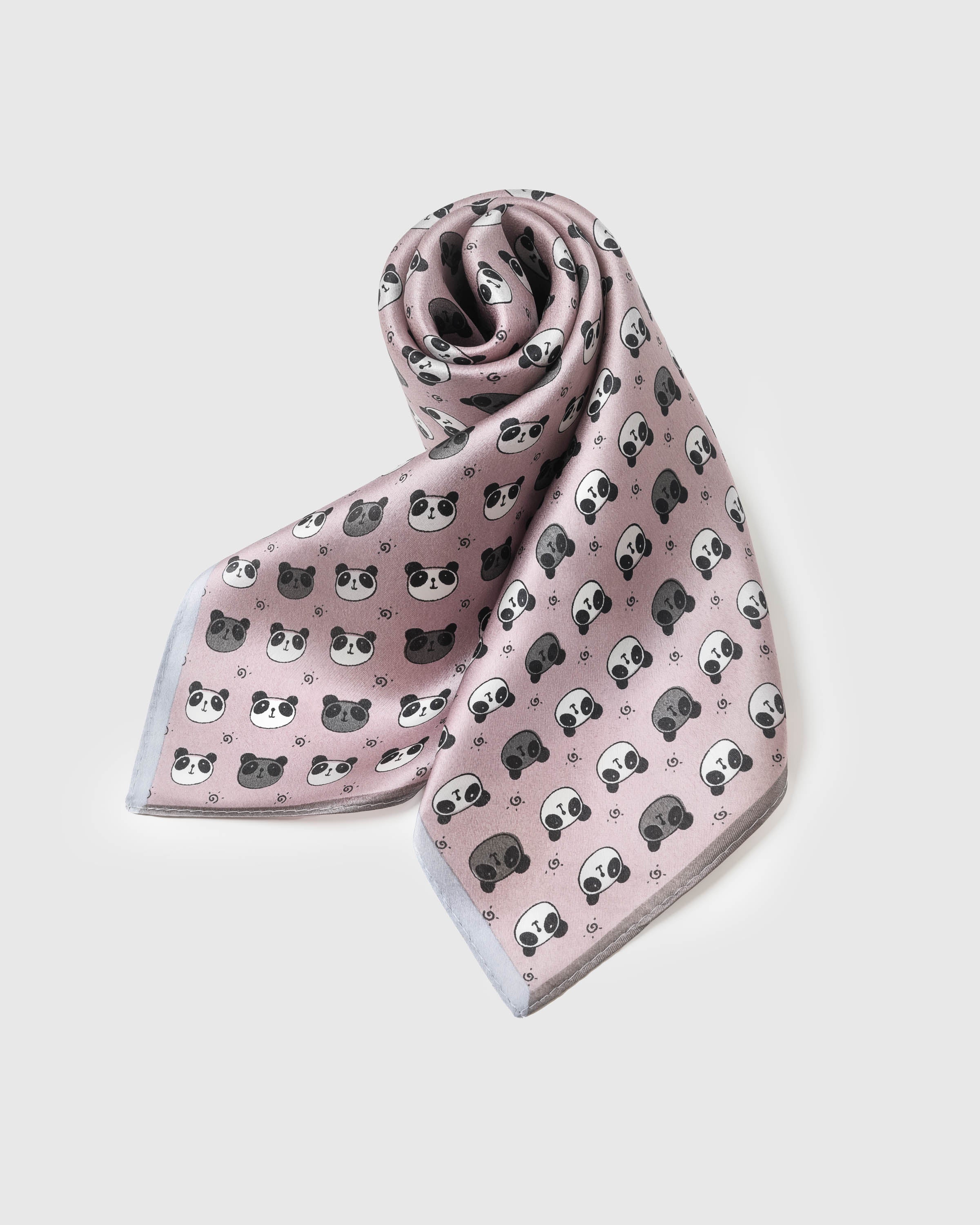 Blush silk panda scarf coiled to show the soft drape and the charcoal print on pure silk
```